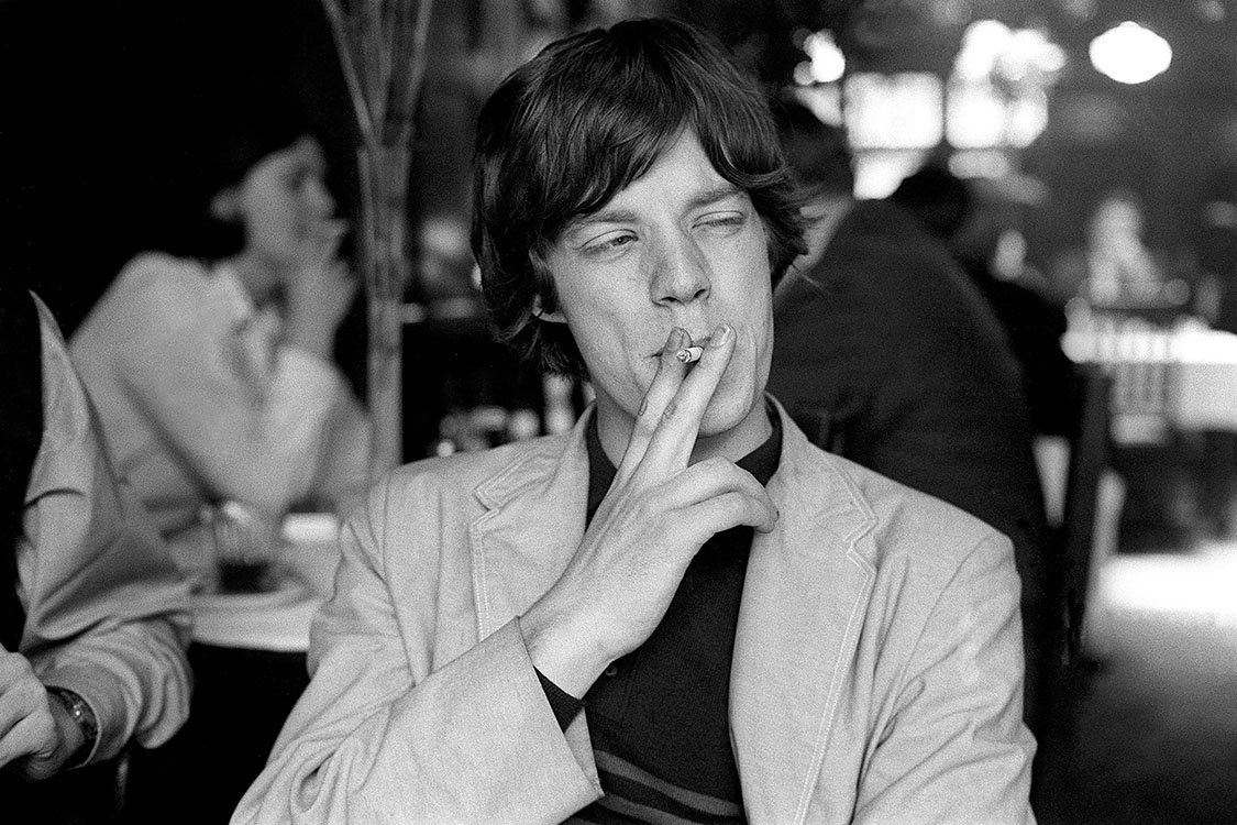 Mick Jagger raucht einer Zigarette (oder Cannabis)
