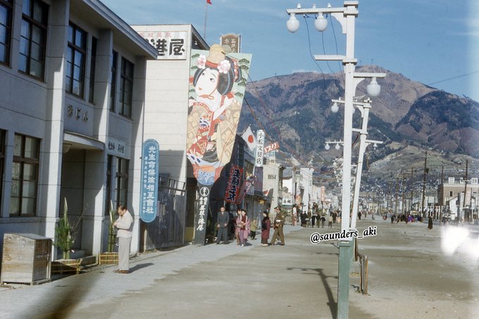 1951年、正月を迎えた呉市の本通。三丁目辺りでしょうか？右手には三和銀行が見えます。左手には港屋呉服店に興味を示すオー