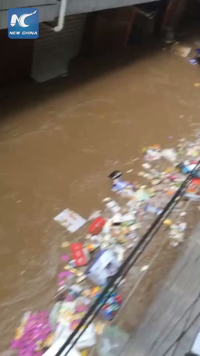 Floodwaters wash products off their shelves in a supermarket in Ganzhou, China