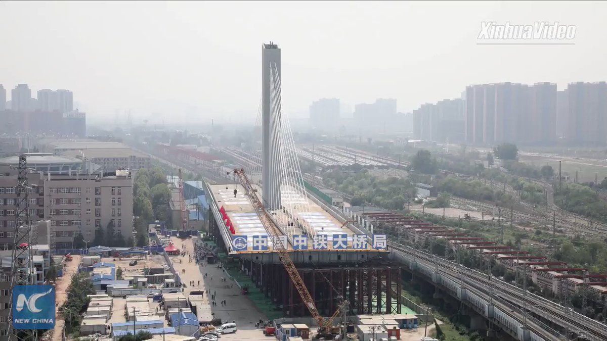A 36,000-tonne cable-stayed bridge rotates to its position above 11 railway lines in Wuhan, central China