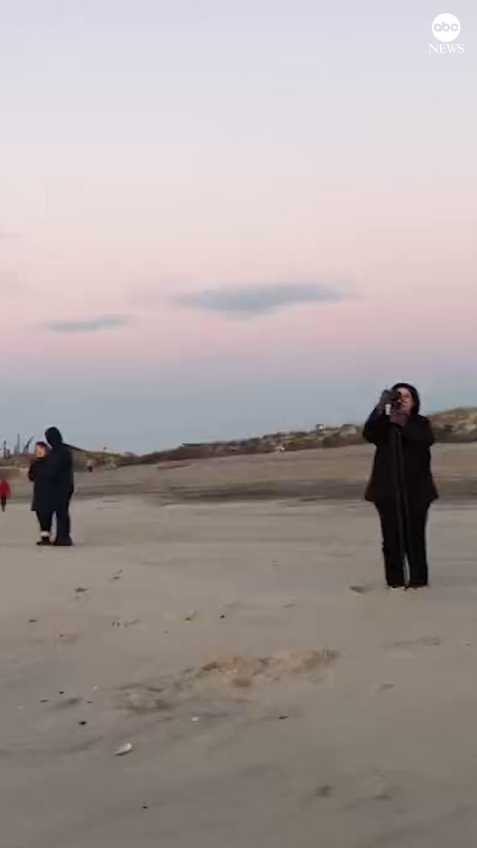 here-comes-the-sun-people-gathered-on-a-long-island-beach-to-view-the