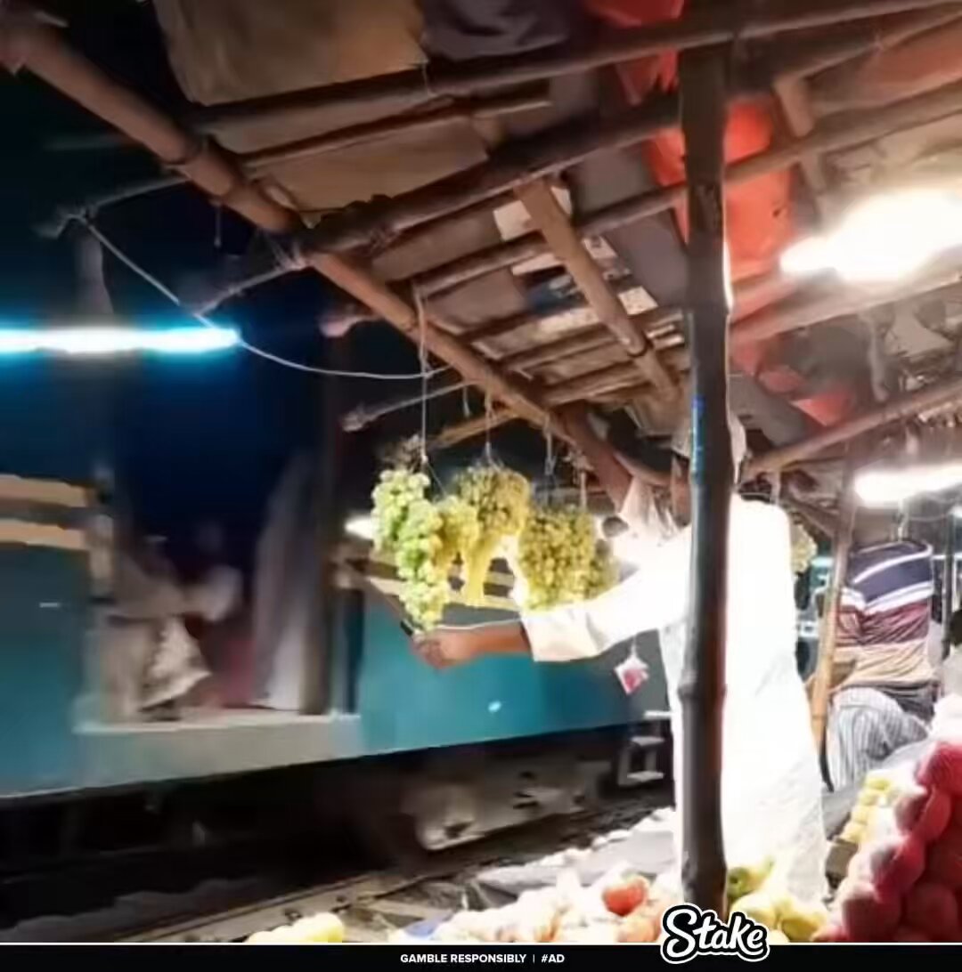 Fruit vendor protecting his grapes from train passengers in Bangladesh 