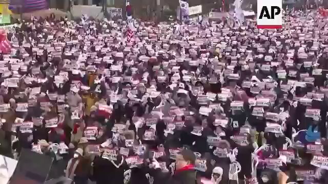 事情发生反转，大批支持尹锡悦的韩国民众在总统官邸前，高举美国和韩国国旗，抗议法院批准逮捕尹锡悦的命令。 