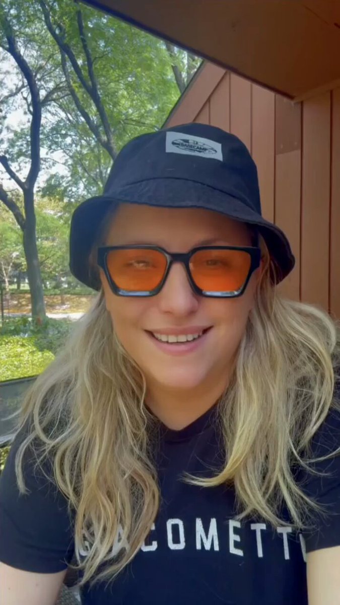 Rachel Wilkins wearing a black bucket hat and sunglasses, discussing her podcast journey