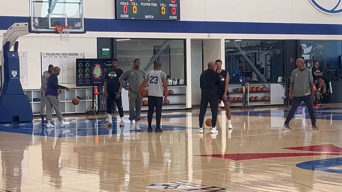 Sixers guard Quentin Grimes appears to be in good spirits while chatting with assistant Rico Hines. Grimes signed his $8.7 million qualifying offer last week to return to the team. 