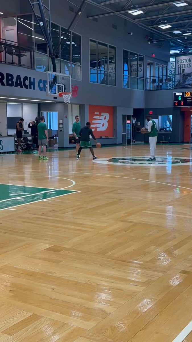 Jayson Tatum stops to talk with Tom Thibodeau while Jaylen Brown gets shots up after practice. 
