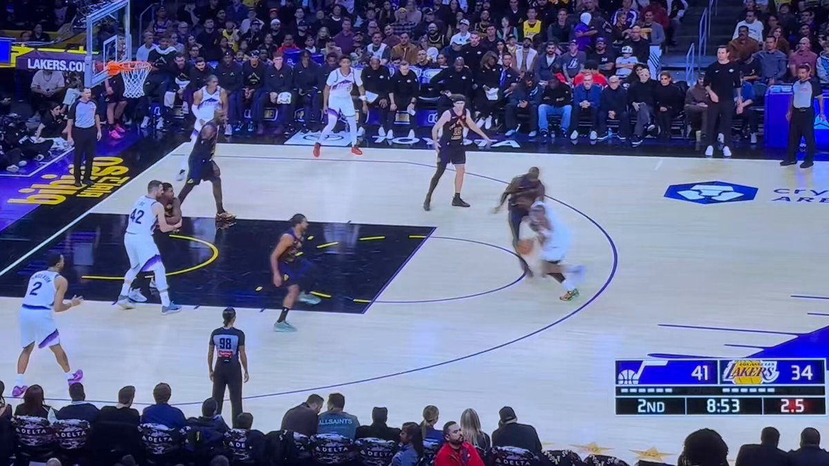 Normally, foot to foot contact like this is a simple defensive foul. Even though defender's foot was "there" first, if he causes the offensive player to trip, it's a defensive foul. Refs opt to play on 🤷‍♂️ 