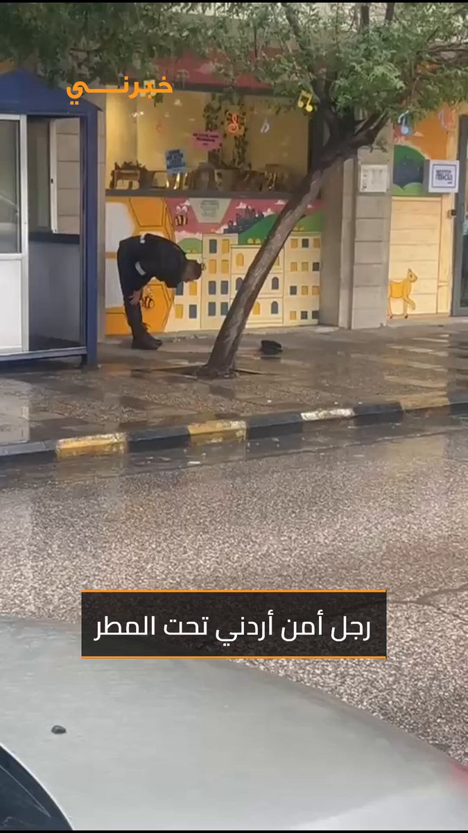 الله يقبل... رجل أمن تحت الأمطار في منطقة اللويبدة بالعاصمة الأردنية عمّان 