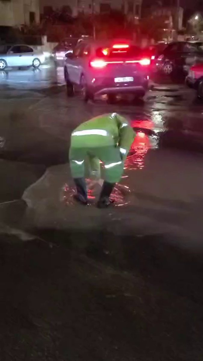 عامل وطن يحاول فتح منهل أغلقته مياه الأمطار الغزيرة في عمان. (تصوير: أمجد الطويل) #جريدة_الغد 