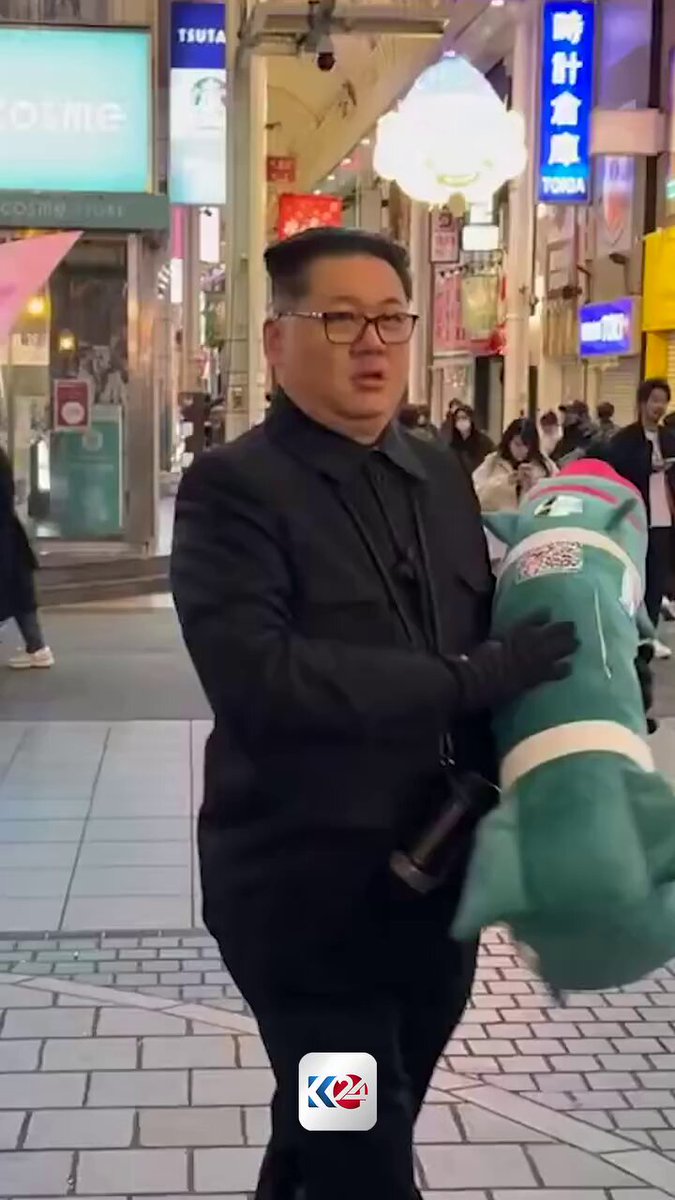 متداول | شبيه زعيم كوريا الشمالية يتجول في مدينة أوساكا اليابانية ويحمل في يده دمية على شكل صاروخ نووي 