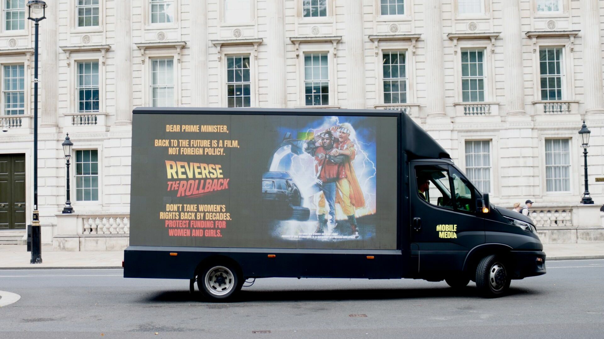 oxfamgbpress's tweet card. Care International organised for an LED truck to circle Westminster.
