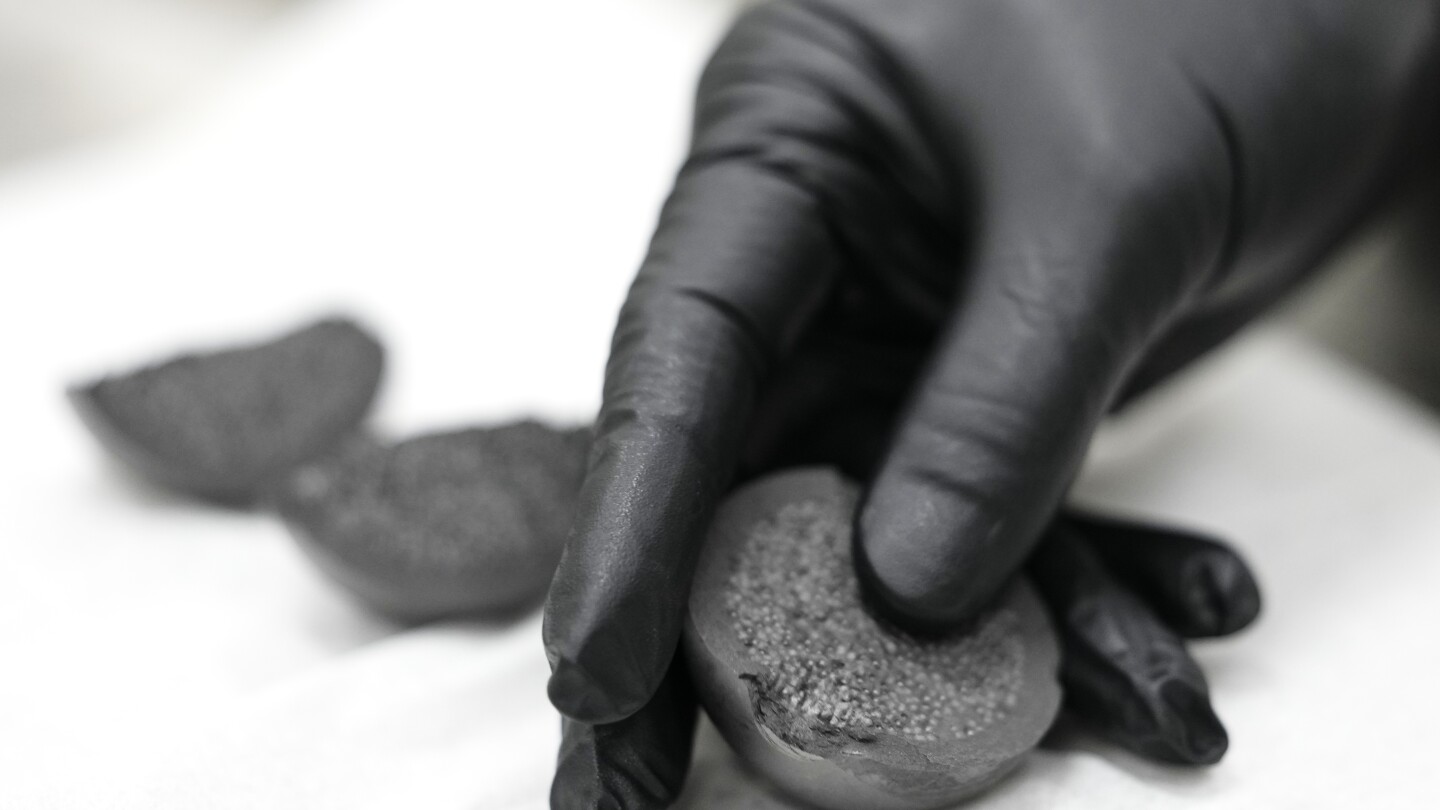 NEI's tweet card. At Oak Ridge National Laboratory in Tennessee, a half-dozen workers are making what appear to be gray billiard balls.