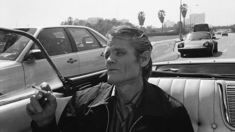 DonStradley's tweet card. Weber teases the old glamor of Baker, filming him in the backseat of a convertible, a woman on each arm.