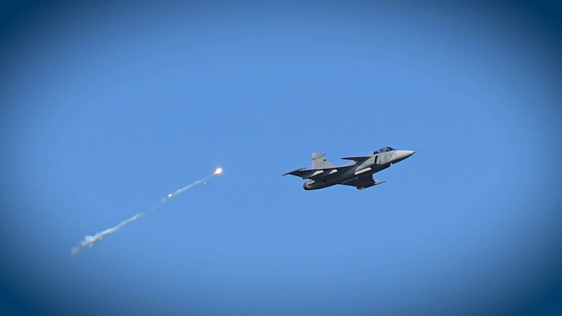 GripenNews's tweet card. Här flyger ett Jas Gripen-plan över Åhus – till tonerna av Top Gun-låten.