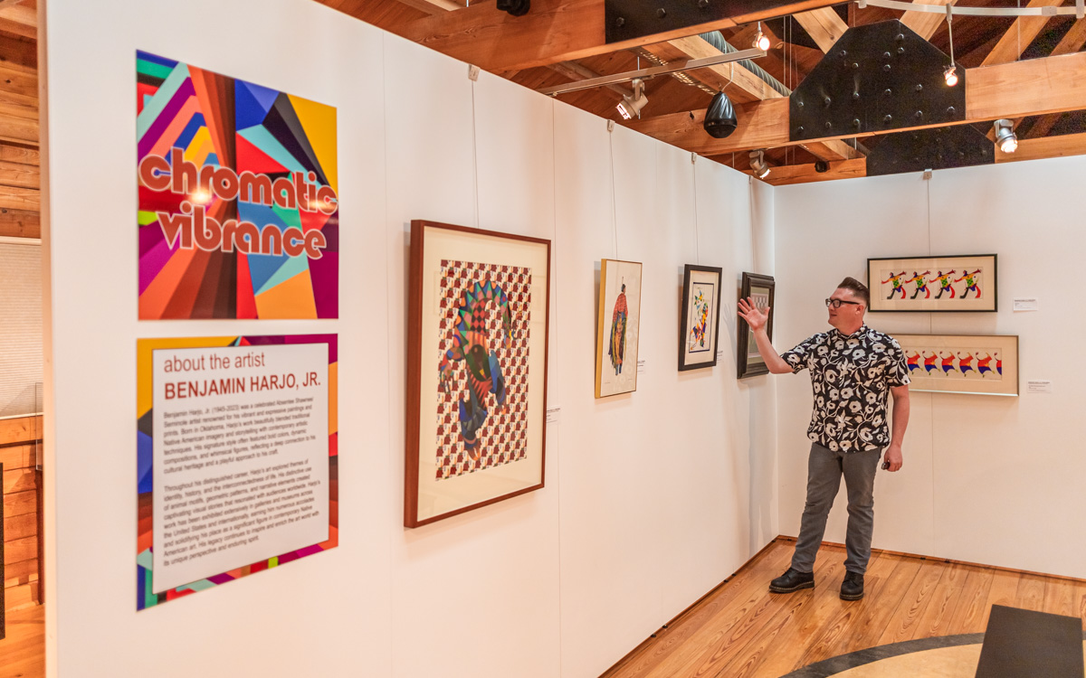 LawrenceKSTimes's tweet card. A temporary art exhibit at Haskell, boasting saturated hues and energetic patterns, depicts a modern Indigenous experience through the pen and brush of career artist Benjamin Harjo Jr.