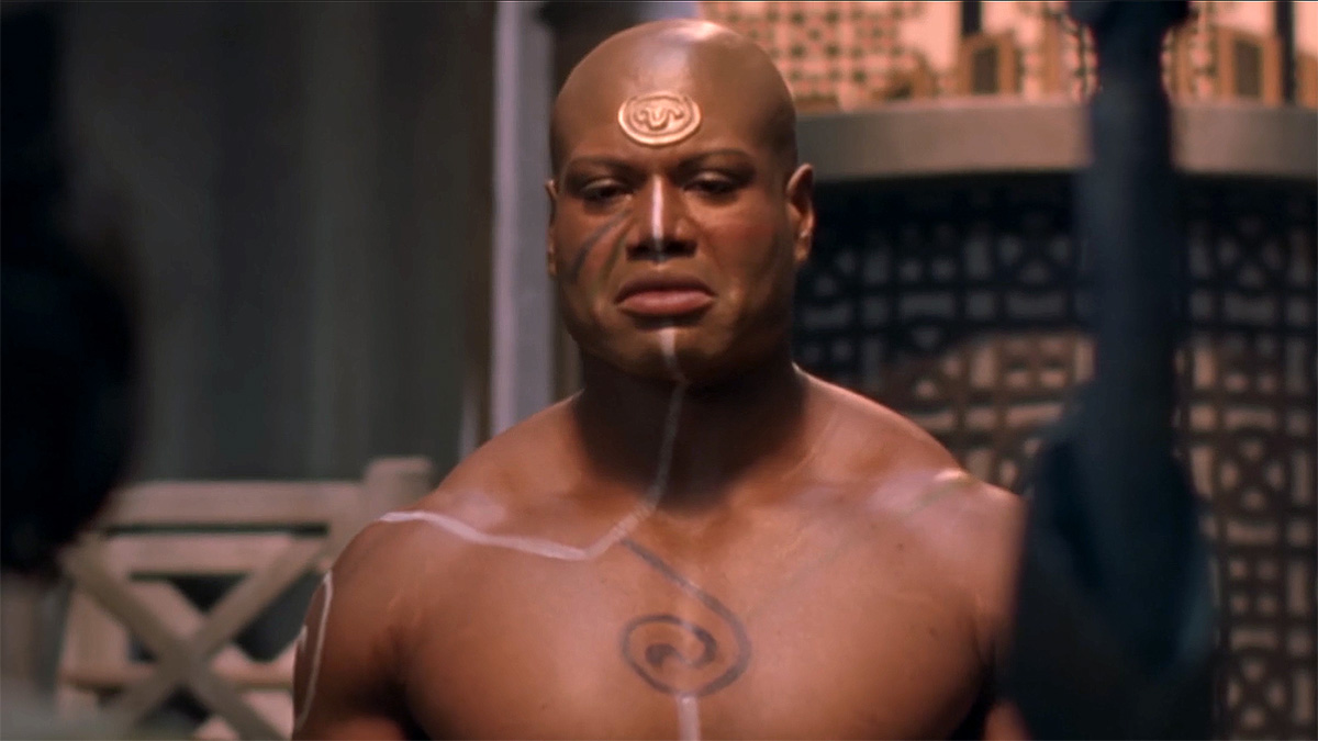 GateWorld's tweet card. Writer Tom J. Astle talks about Teal'c's character in the important first-season episode "Cor-ai" – and who he thinks the episode is really about.