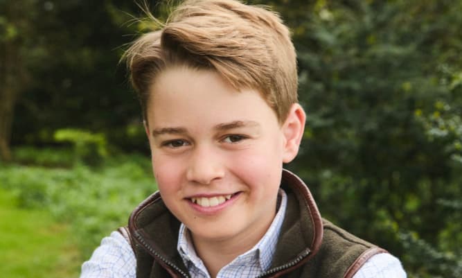 RFitzwilliams's tweet card. The photograph shows George outdoors, smiling and leaning on a rustic wooden gate in Norfolk