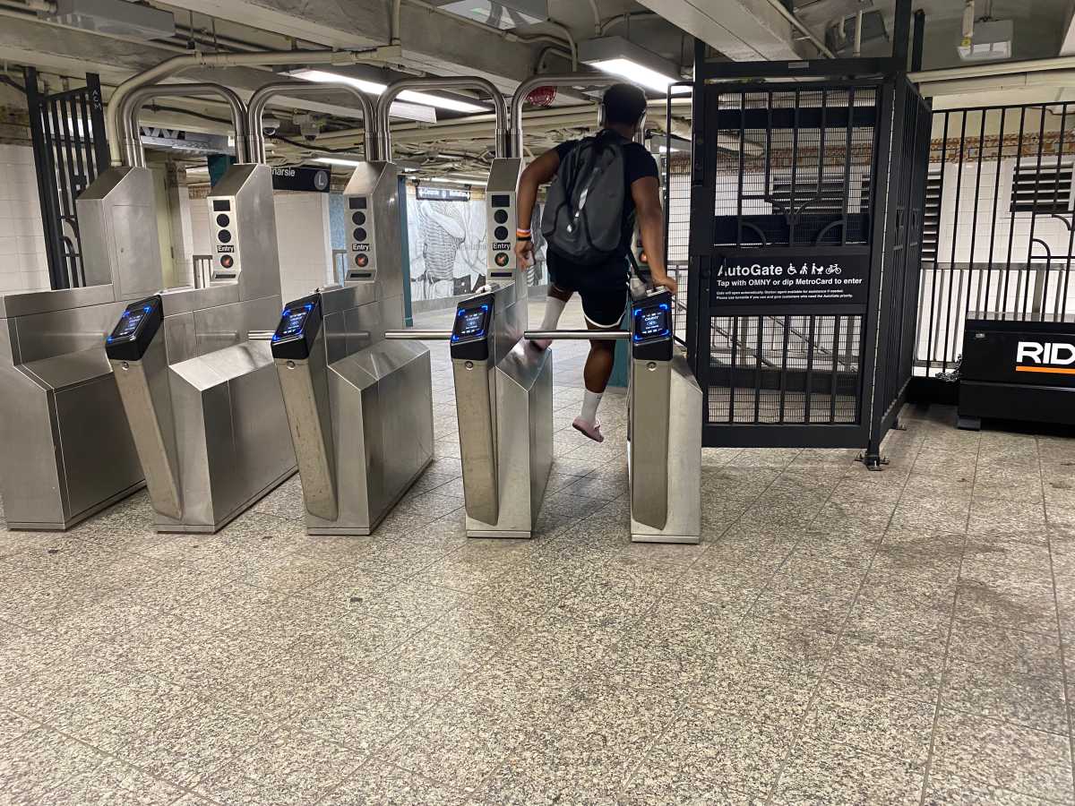 amNewYork's tweet card. Witness brazen fare evasion at this Brooklyn subway where turnstile jumpers operate openly near station agents, highlighting NYC's $800M fare-dodging crisis.