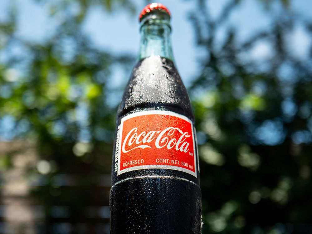nationalpost's tweet card. Coca-Cola to release new Coke with sugar. Trump says it's 'better' than corn syrup. Is it?
