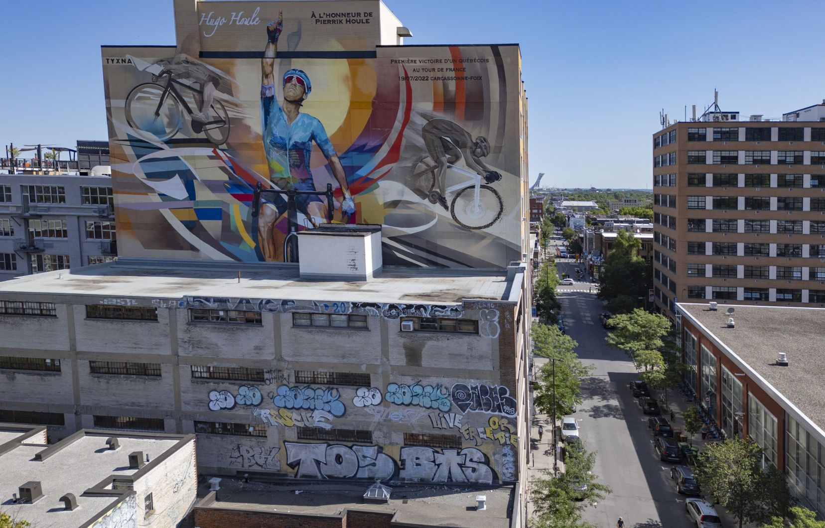 LeDevoir's tweet card. Une murale a été peinte en honneur au cycliste québécois, sur l’avenue du Mont-Royal.