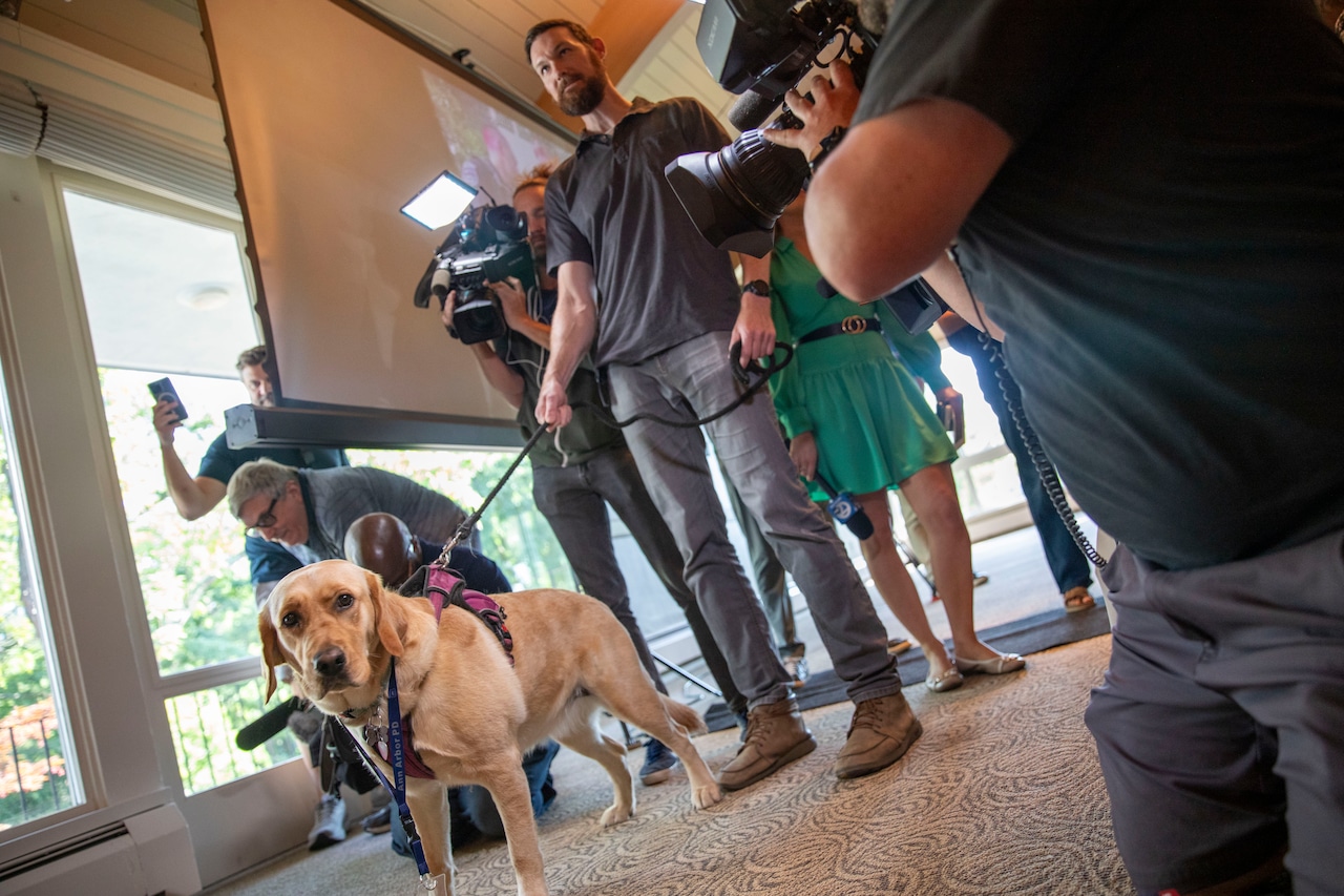 MLive's tweet card. Ben Osenbaugh, 39, and his golden lab, Dolly, received recognition at a ceremony for finding former University of Michigan professor of chemical engineering Ralph Yang.
