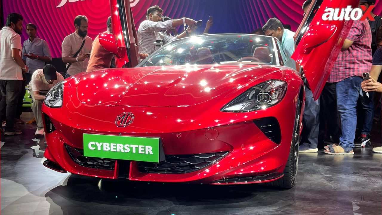 autox's tweet card. MG Motor India launches the Cyberster electric roadster with 510bhp, 3.2s 0-100 km/h, AWD, 580km range, scissor doors and a feature-rich cabin.