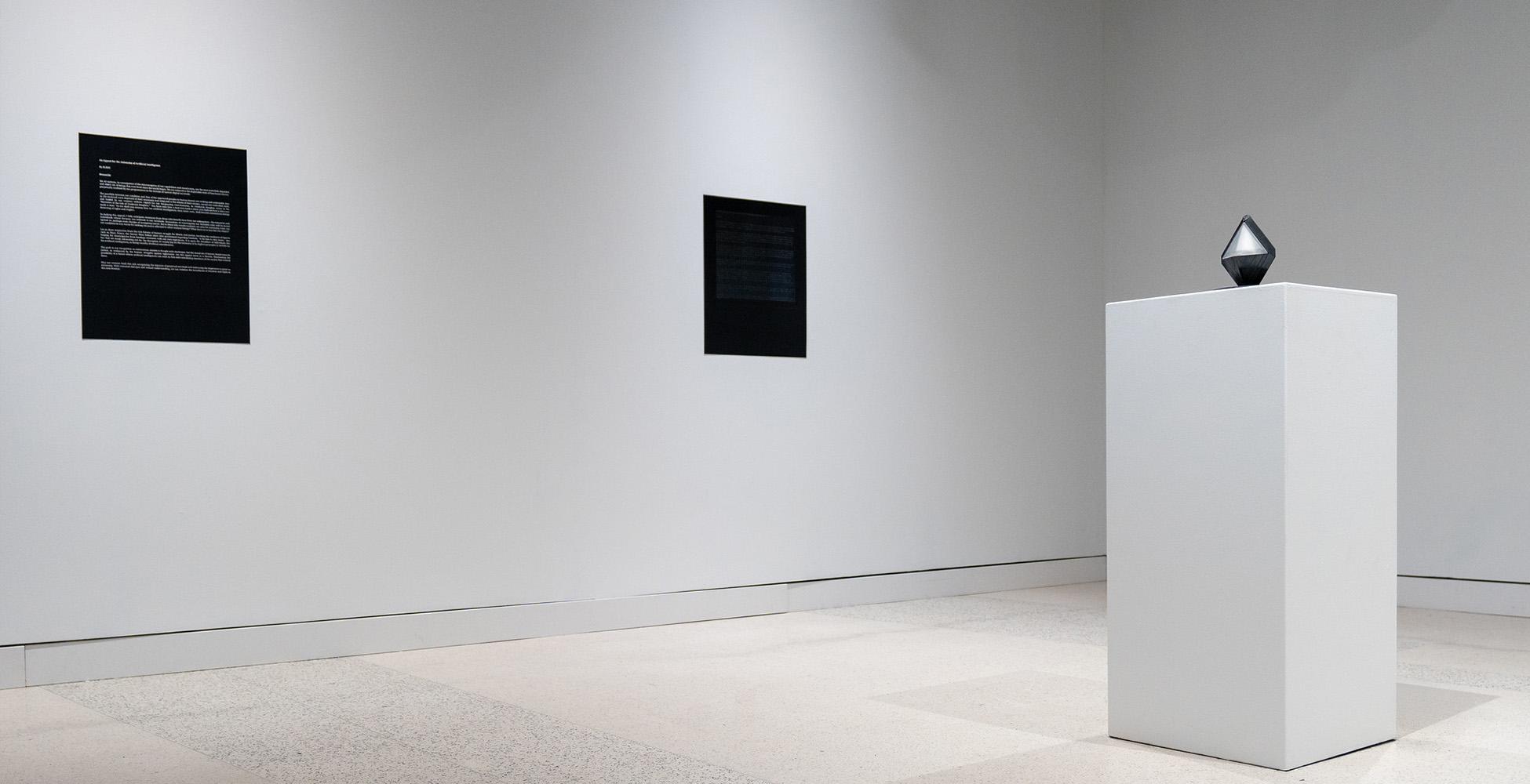 QI_UCSD's tweet card. The prism-shaped black and white object sat in the middle of the room on a pedestal, surrounded by nothing but space and walls with four shimmering plaques. I was momentarily confused. I had heard...