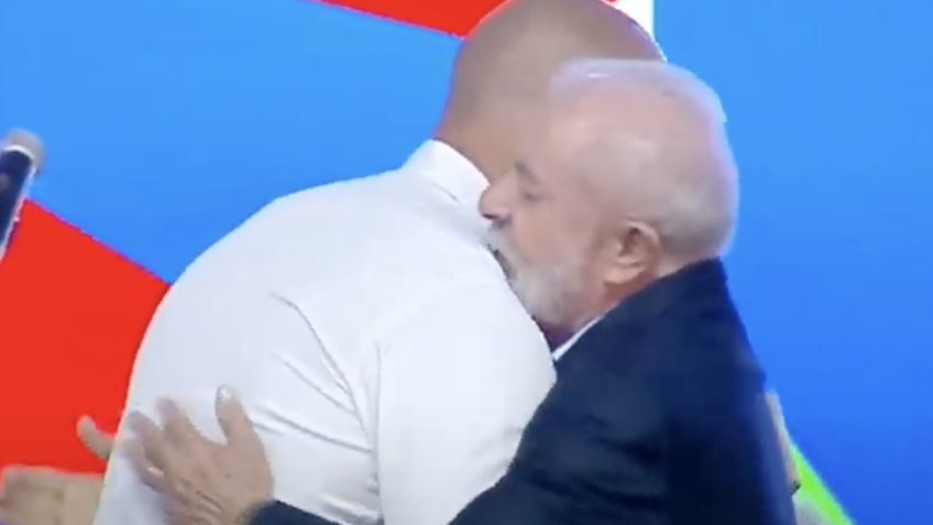 Poder360's tweet card. Presidente esteve em pé ao lado de Gerson Pessoa durante fala; se abraçaram ao final do discurso. Leia no Poder360.