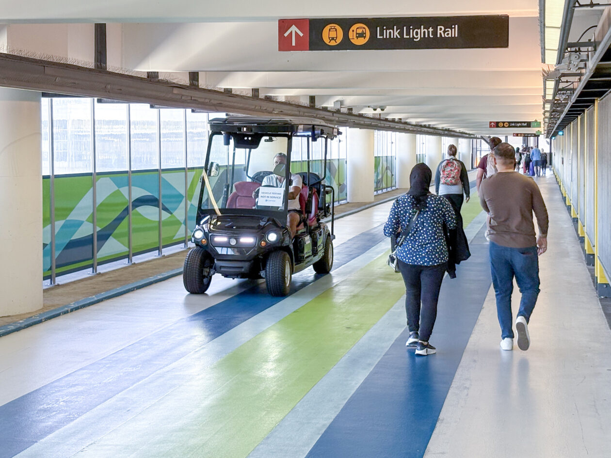 geekwire's tweet card. A driverless shuttle, pictured here with a quality assurance engineer onboard, makes the run on the walkway between the Sound Transit light rail station