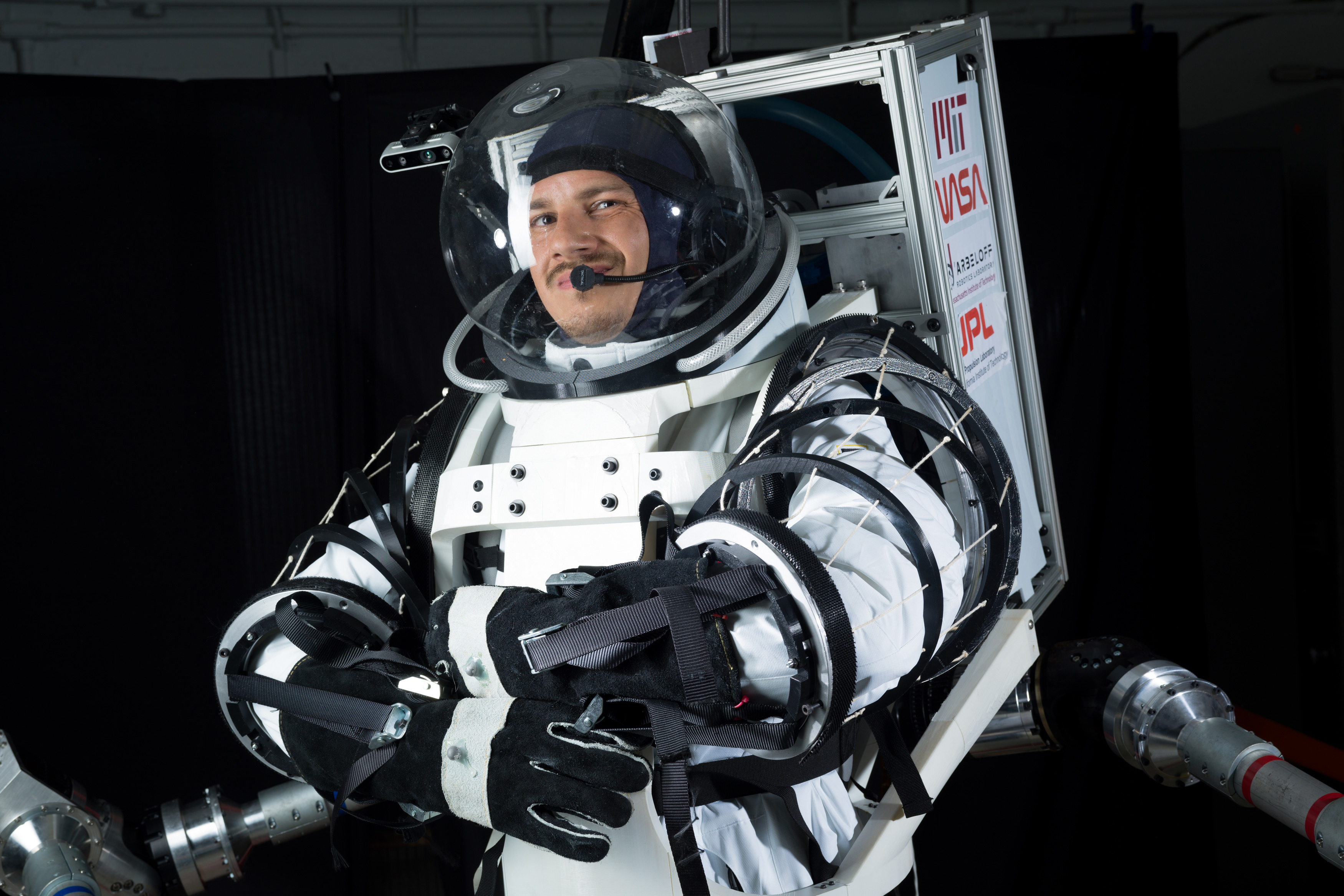 MITEngineering's tweet card. MIT PhD student Erik Ballesteros is developing a pair of wearable robotic arms that can lift an astronaut up if they fall. The arms could also crab-walk around a spacecraft’s exterior as an astronaut...