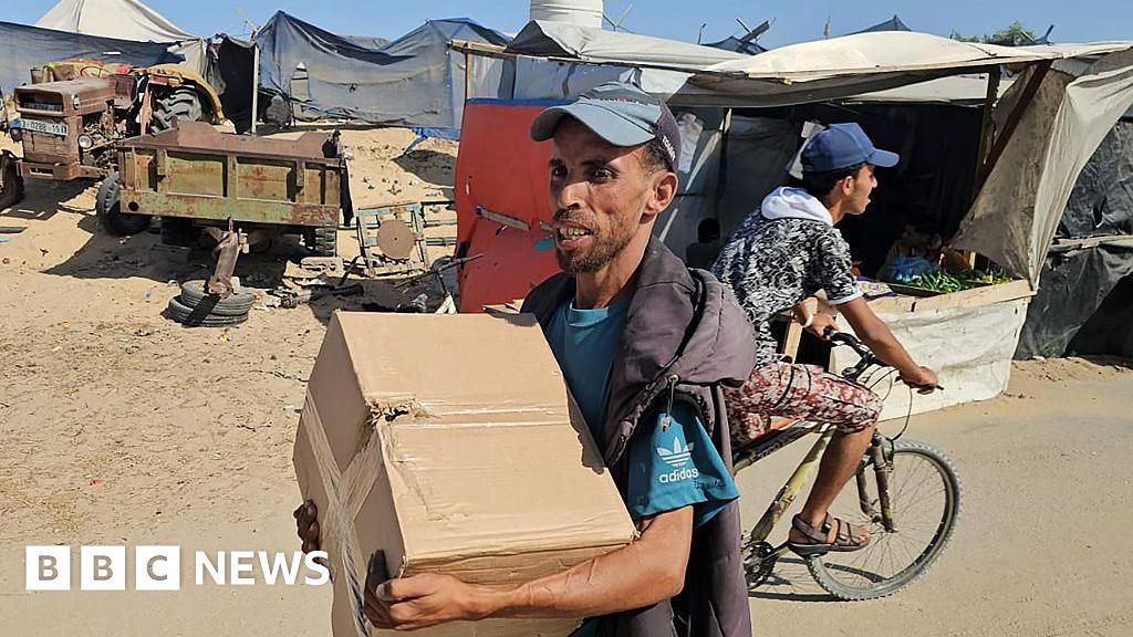 stackemup332's tweet card. Hundreds of Palestinians collect food from a site run by the Gaza Humanitarian Foundation, whose work the UN calls a "distraction".