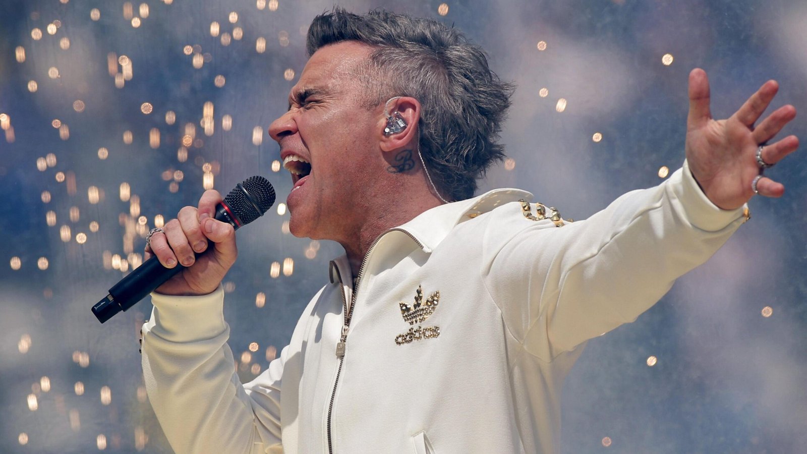 conectageekofc's tweet card. Robbie Williams adia lançamento de ‘BRITPOP’ para 2026 após sucesso estrondoso de novo álbum de Taylor Swift nas paradas e no streaming.