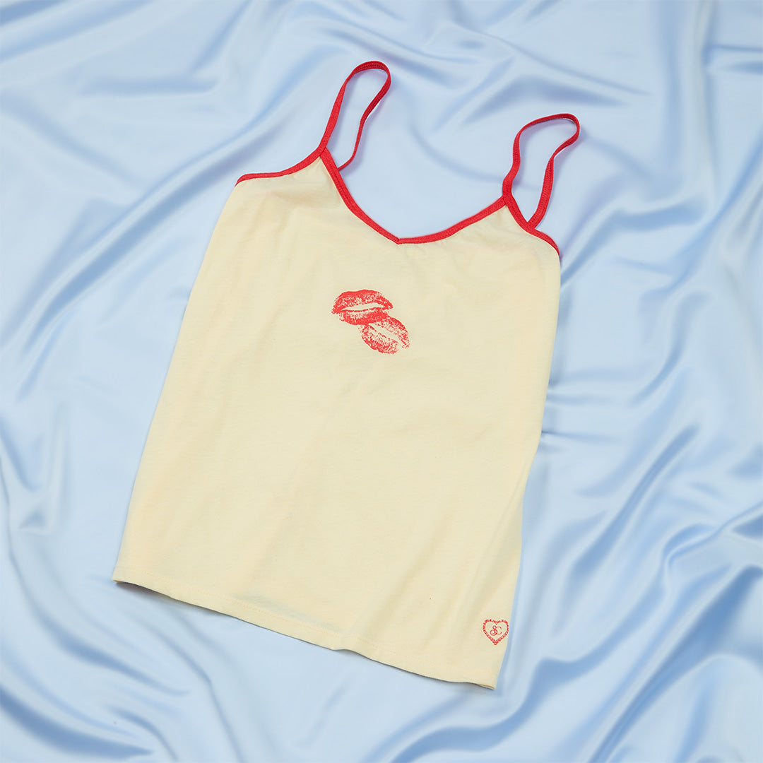 sabrinamerch_py's tweet card. the perfect tank for when you're craving some fresh air - keep it light! creme cami tank top with red trim and screen printed kiss mark.
