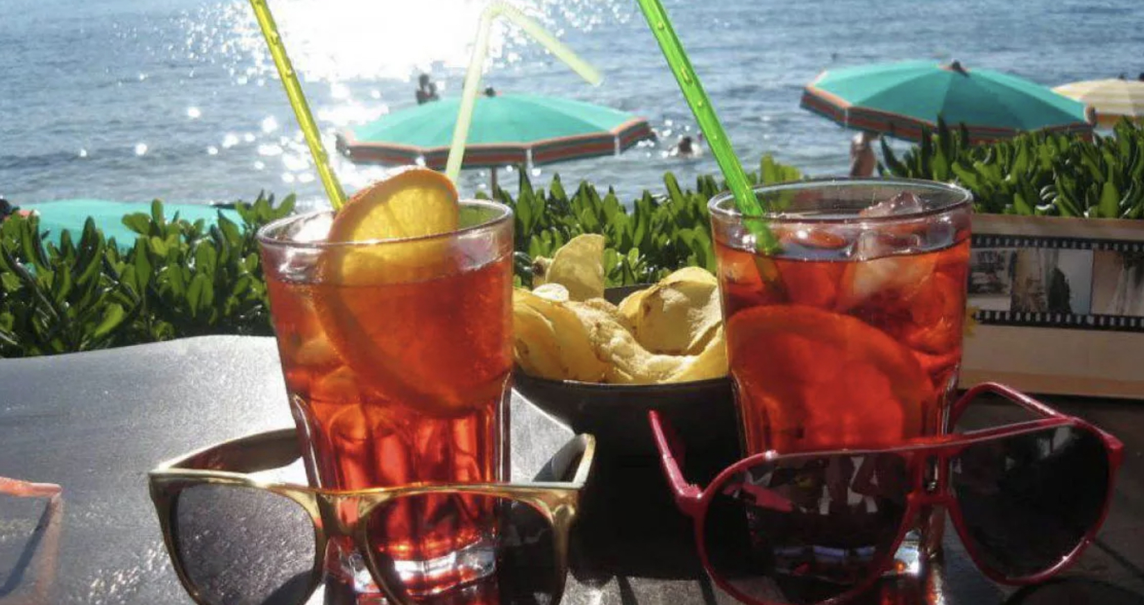 repubblica's tweet card. Terrazza di un albergo sul mare, ora del tramonto. Arriva una coppia, è per l’aperitivo. Fa caldissimo. Lui: giacca e camicia executive, enorme costoso orologio al polso, braccialettini di corallini...