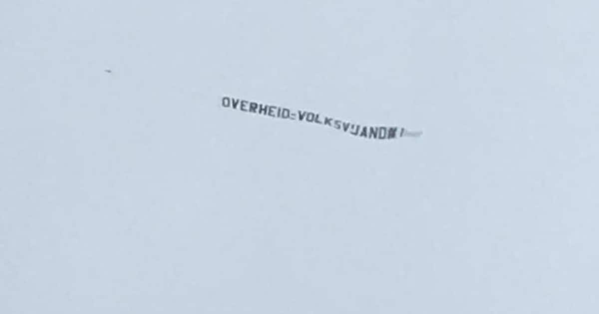 SillySigns1's tweet card. Er vliegt momenteel een vliegtuigje boven Den Haag met een opvallende ‘luchtreclame’. Er valt te lezen: ‘Overheid volksvijand #1'.