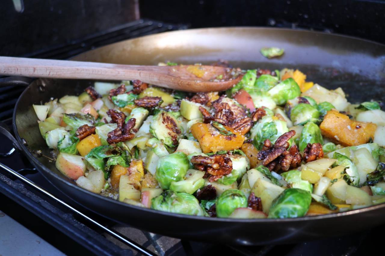 ManTripping's tweet card. Fall skillet recipe featuring butternut squash, Brussels sprouts, and apples cooked on a Weber Spirit grill using a Smithey paella pan. Perfect seasonal dish with local Michigan ingredients and...