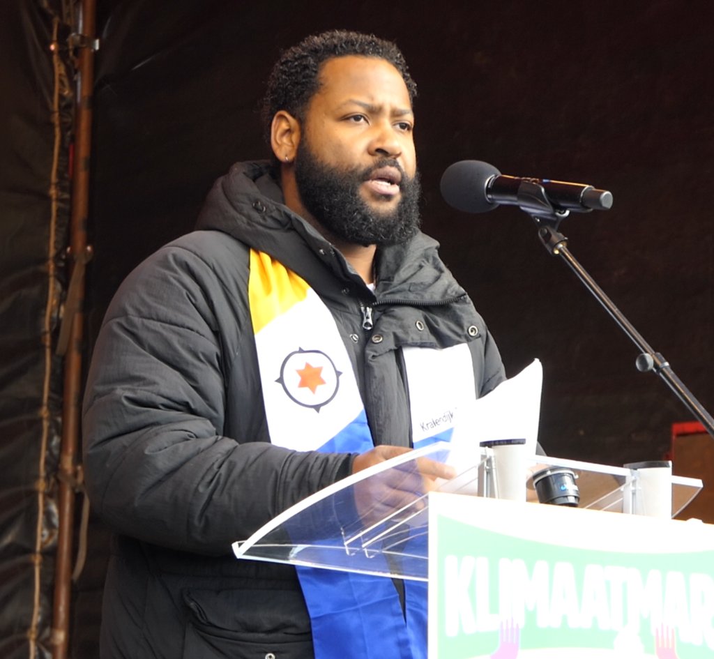 SupportOccupyNL's tweet card. Vandaag hield Kjelld Masoud Kroon, een van de eisers in de klimaatzaak van Bonaire tegen de Nederlandse staat, een indrukwekkende toespraak bij de klimaatmars in Den Haag. Hier de integrale uitgesc...