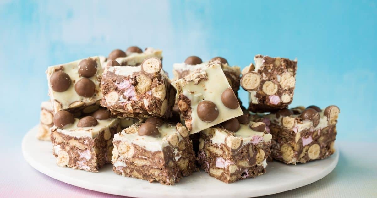 PinkOddy's tweet card. Malteser Rocky Road made from crushed malt biscuits, mini marshmallows, milk, dark and white chocolate and of course...oodles of Maltesers. This is the easiest, quickest and most delicious no-bake...