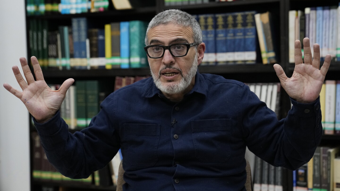 1drewbarker's tweet card. A British Palestinian surgeon who volunteered in Gaza hospitals says he was denied entry to France to speak at the French Senate.