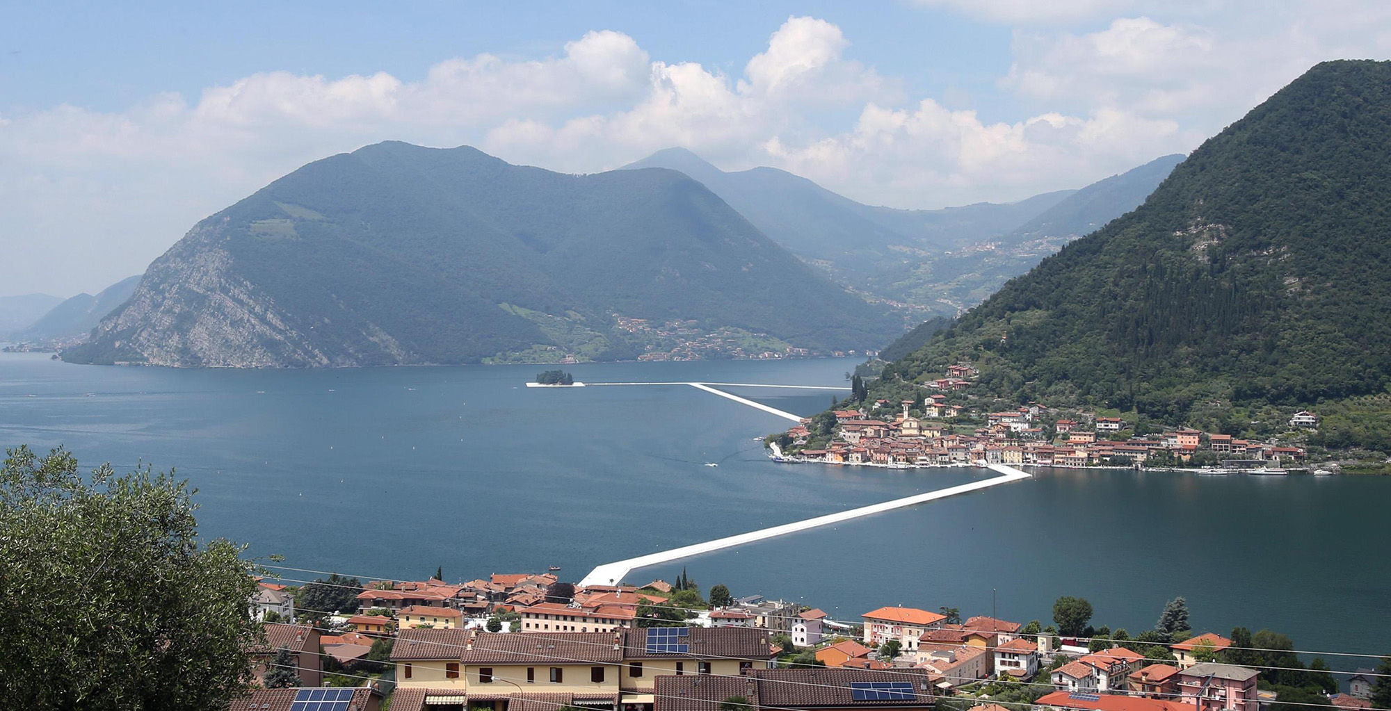 INSPARCHITECTS's tweet card. The foundations for the pier that will span Italy’s three-mile-wide Lake Iseo have been set and await the signature cloth covering for which the land artist couple is famous.