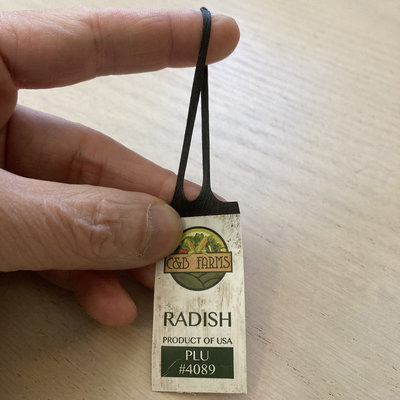 Delve_Design's tweet card. I bought some radishes at the supermarket and they came with this unusual tag. It's like a tag was co-molded with a rubber band. I figured there's no way this is recyclable. However, on the back...