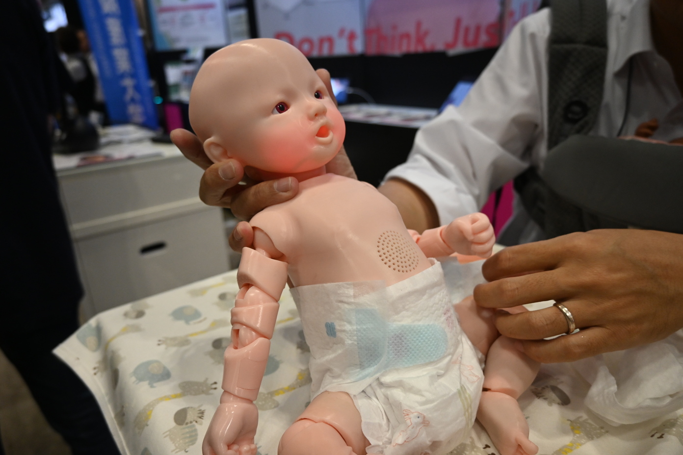 takayuki_kosaka's tweet card. 　10月17日まで開催された「CEATEC 2025」では、「新生児育児体験システムCrying baby」で乳児の子育てを擬似体験できた。