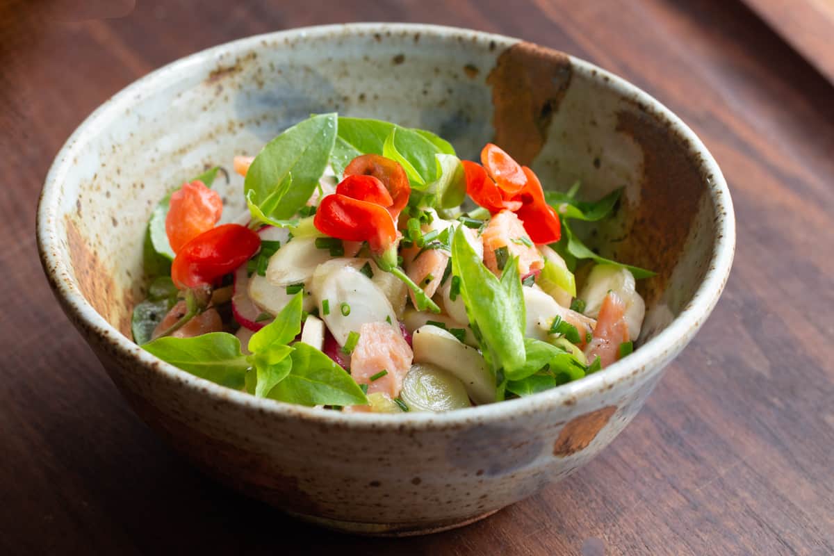 AlanBergo's tweet card. A crisp, refreshing salad made from shaved cattail rhizomes, smoked trout, fresh tarragon, mint, lemon, chickweed or purslane tips is a delicious homage to aquatic edibles.