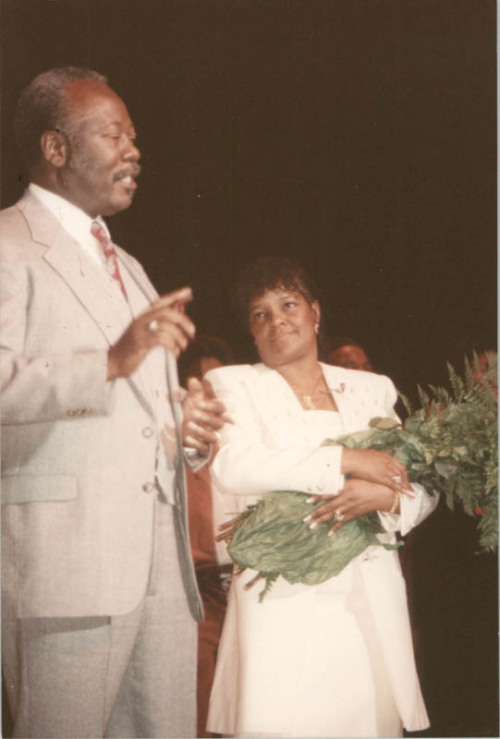 LCDigitalLib's tweet card. Photograph of Bill Saunders Speaking Color photograph of Bill Saunders with a woman holding a bouquet of flowers. From the William (“Bill”) Saunders Papers, circa 1950 - 2004 held at the Avery...