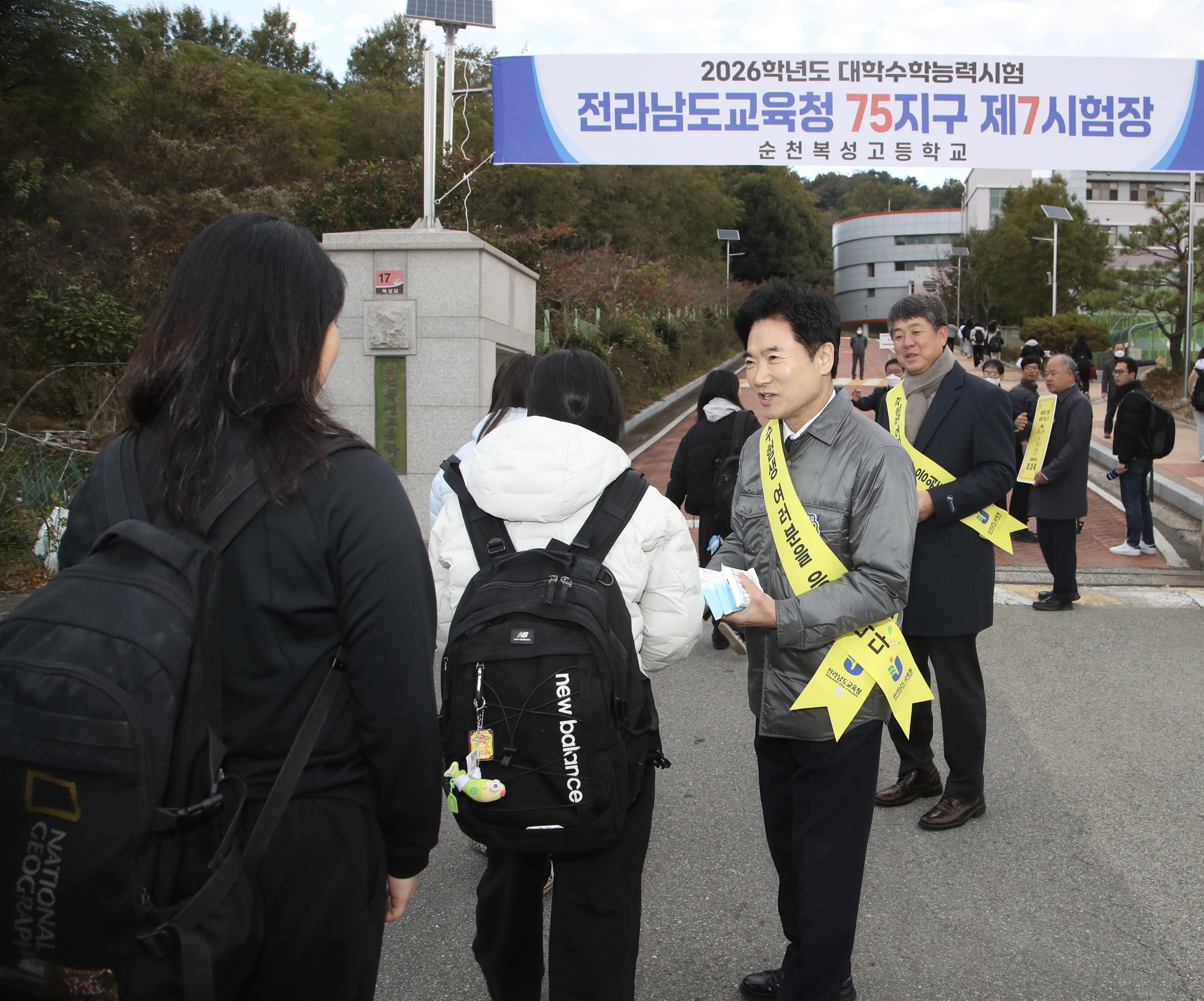 OhmyNews_Korea's tweet card. 김대중 교육감 등 전라남도교육청 간부들이 2026학년도 대학수학능력시험일인 13일 시험장을 찾아 수험생을 응원했다.김 교육감과 교육청 간부들은 이날 오전 75지구 제7시험장인 순천복성고등학교 교문 앞에서 수험생들을 반갑게 맞이하