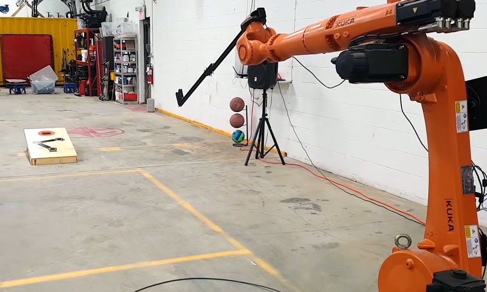 EmmaMai_'s tweet card. David Niewinski of Dave’s Armoury won the ‘Jetson Project of the Month’ for building a robot arm capable of playing a perfect game of cornhole.