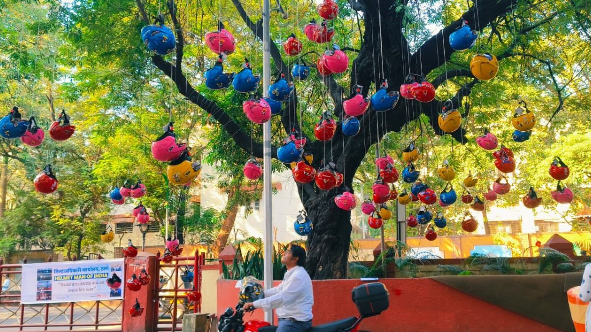 LoksattaLive's tweet card. Helmet Tree Initiative Thane Unique Public Awareness Drive Rub 99 - ठाण्यातील जिल्हाधिकारी कार्यालयाबाहेर चक्क हेल्मेटचे झाड दिसून येत आहे. या झाडावर विविधरंगी हेल्मेट दिसून येत आहेत.. Latest Marathi...
