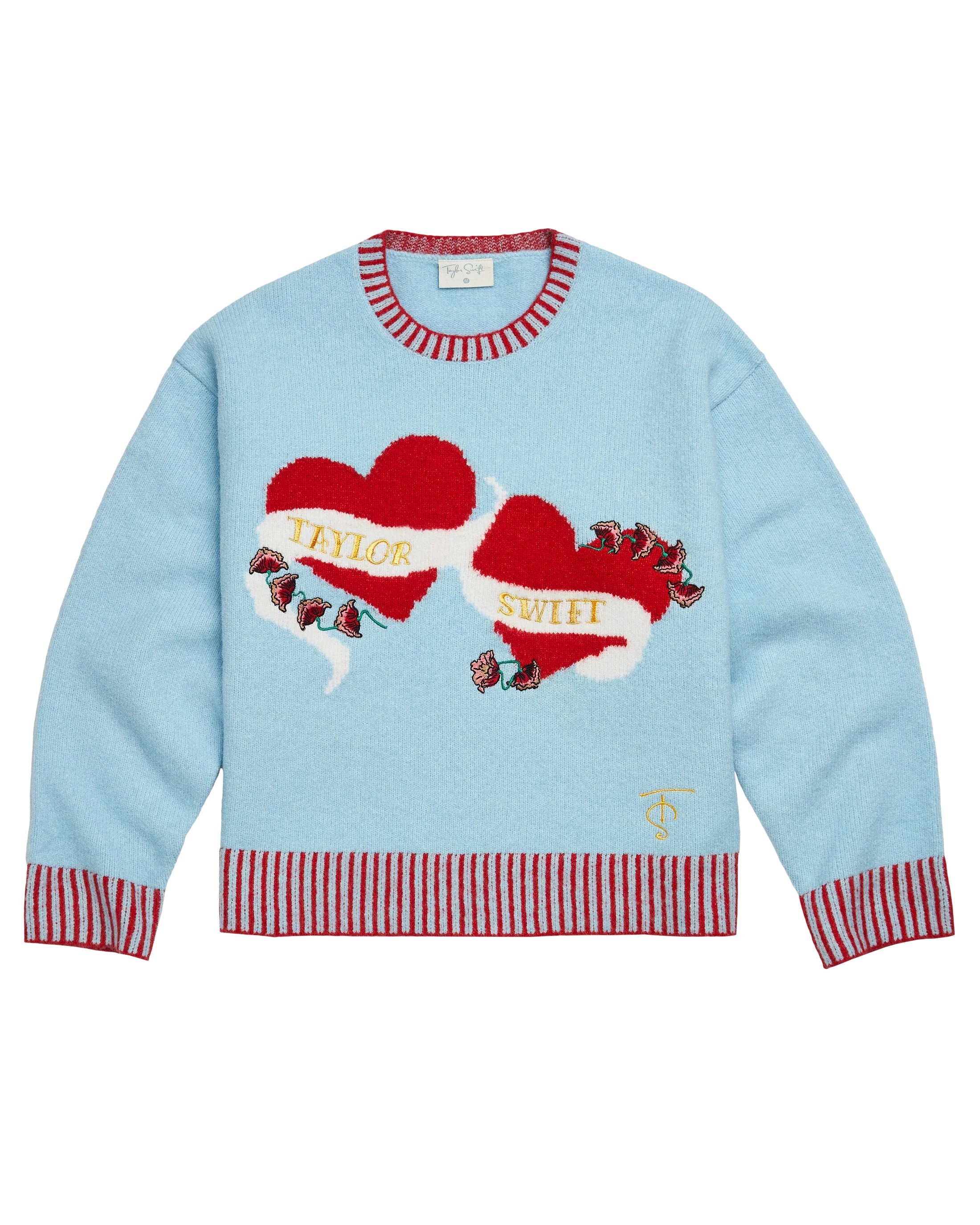 swiftpitch_uk's tweet card. Ships within 10 daysBlue sweater with red stripe trim featuring hearts knitted design on front with "Taylor Swift" logo and flower design embroidered on front and "TS" logo embroidered on wearer's...