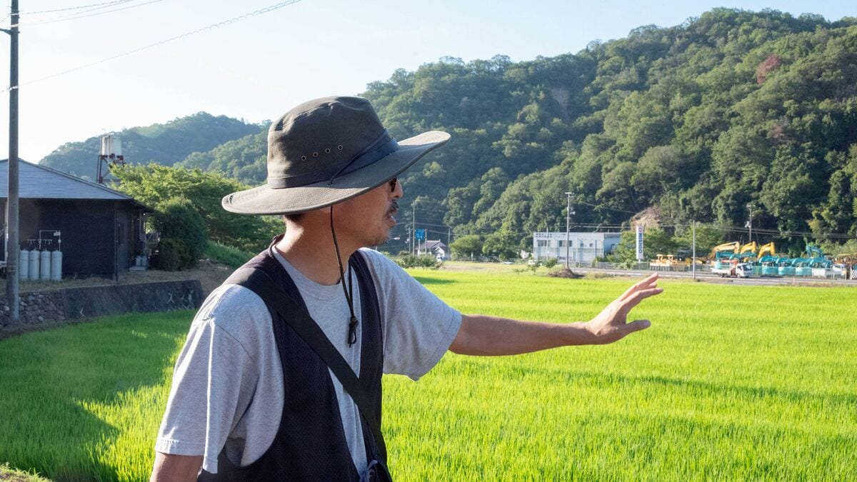 SzkCurryWeb's tweet card. 「限界集落」とされる人口309人の広島県竹原市田万里（たまり）町に、年間3万人が訪れるドーナツ専門店とファームステイの宿「田万里家」がある。仕掛けたのは、44歳で広告業界から農業に飛び込んだ、井本喜久さん（50歳）だ。井本さんは田万里家で、何を実現しようとしているのか。ライターの山口ちゆきさんがリポートする――。