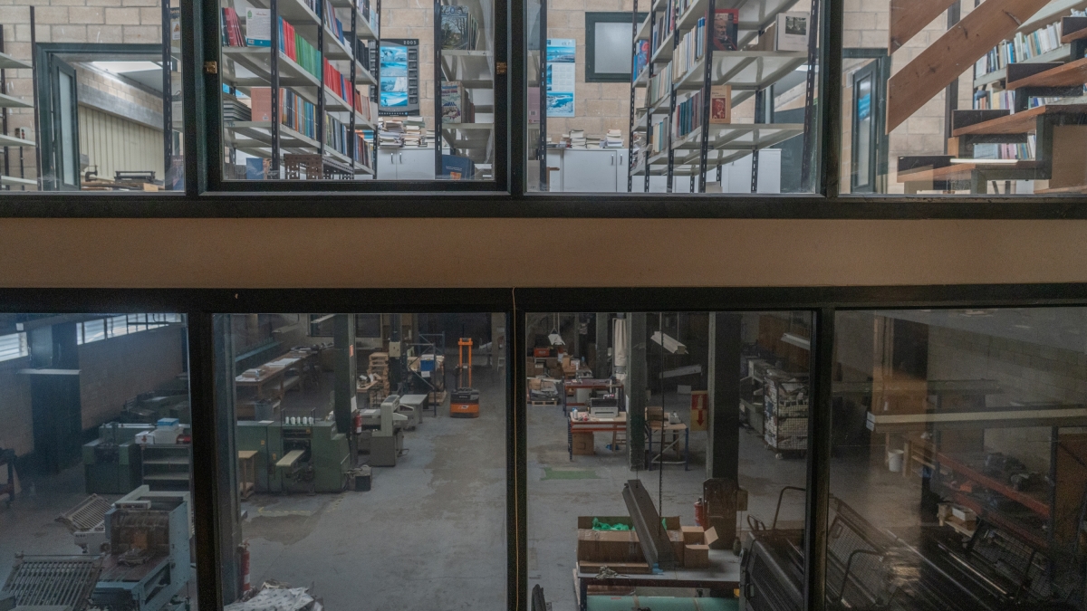 berria's tweet card. Lau iltzerekin hormara jositako plakan, Editorial Itxaropena Argitaldaria hitzak berun gainean. Eta pauso gutxi ezkerretarantz, leihoetako batean gorago, paseatzaile eta errepideko gidarientzat dez...